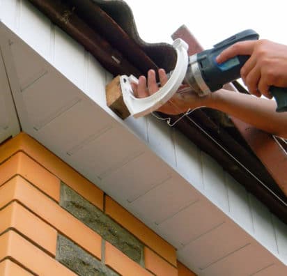 Contractor installing gutter system